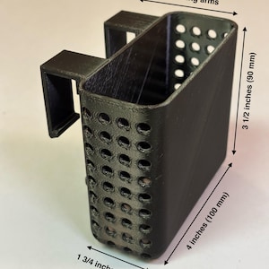 May include: A black, rectangular basket with a handle, featuring numerous circular perforations. The basket is 4 inches (100 mm) long, 3 1/2 inches (90 mm) tall, and 1 3/4 inches (42 mm) wide. The text "20 gallon tall" is visible.
