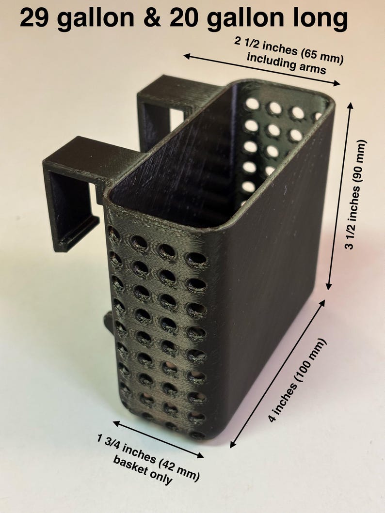 May include: Black rectangular basket with perforated sides, designed for aquarium use. The basket measures 4 inches (100 mm) long, 3 1/2 inches (90 mm) high, and 1 3/4 inches (42 mm) wide. Includes arms that extend 2 1/2 inches (65 mm). Text reads "29 gallon & 20 gallon long".