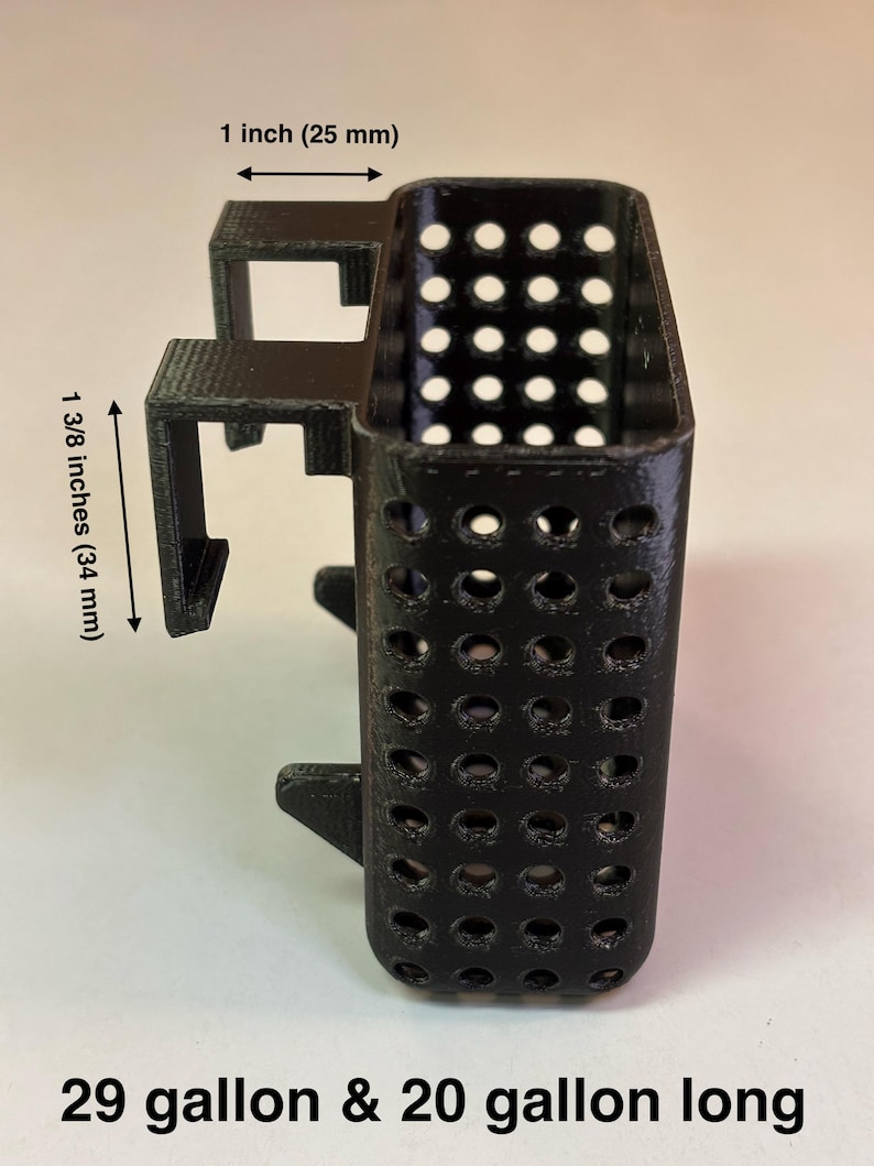 May include: Black, 3D-printed aquarium accessory with a rectangular perforated container and mounting brackets. The container is 1 inch (25 mm) wide and 1 3/8 inches (34 mm) tall. Text at the bottom reads "29 gallon & 20 gallon long".