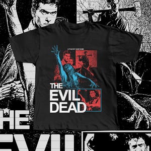 May include: Black t-shirt with a movie poster design for "The Evil Dead." The design features a central image with blue and red tones, and the film's title in white block letters. The shirt also has the text "A Film by Sam Raimi."