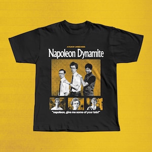 Może przedstawiać: Czarna koszulka z tytułem filmu "Napoleon Dynamite" w białym kolorze i grafiką przedstawiającą trzech mężczyzn. Poniżej grafiki znajduje się cytat "napoleon, give me some of your tots!" z trzema mniejszymi obrazami.