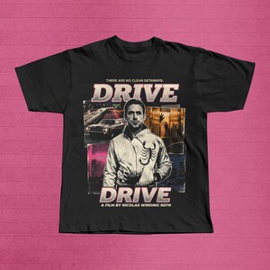 May include: Black t-shirt featuring the movie title "DRIVE" in a retro font, with an image of a car and a man wearing a jacket with a scorpion on it. The text "THERE ARE NO CLEAN GETAWAYS" is above the title, and "A FILM BY NICOLAS WINDING REFN" is below.