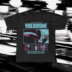Op de afbeelding: Zwart t-shirt met de filmtitel "Videodrome" in turquoise en een afbeelding uit de film. Onder de titel staan drie kleinere afbeeldingen en de quote: "First it controls your mind... then it destroys your body."