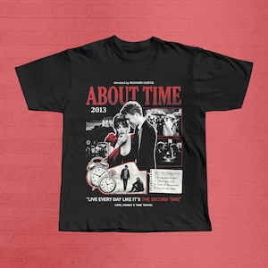 May include: Black t-shirt featuring the movie title "ABOUT TIME" with the year 2013. The design includes images from the film, a quote, and the text "LOVE, FAMILY & TIME TRAVEL."