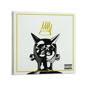 Könnte beinhalten: Quadratischer Leinwanddruck mit einem stilisierten schwarzen und silbernen Kopf mit Hörnern, einer goldenen Krone und einem goldenen Rahmen auf weißem Hintergrund. Der Druck enthält den Text "Parental Advisory Explicit Content".