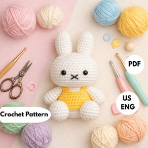 May include: A white crocheted rabbit doll wearing a yellow top, surrounded by colorful yarn balls, metal scissors, and crochet hooks. The image includes text labels that read Crochet Pattern, PDF, and US ENG, indicating a craft project guide.