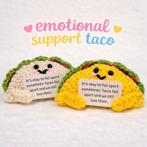 May include: Two crocheted taco plushies, one cream and one yellow, each with a smiling face and a green and red trim. They hold signs that read, "It's okay to fall apart sometimes. Tacos fall apart and we still love them." The text "emotional support taco" is above.
