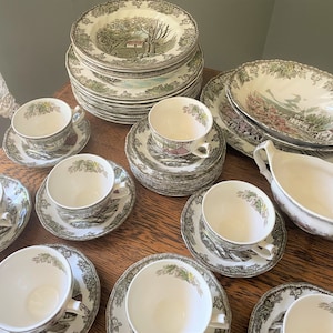 May include: A set of vintage green and white floral patterned china dinnerware, including plates, bowls, cups, and saucers.