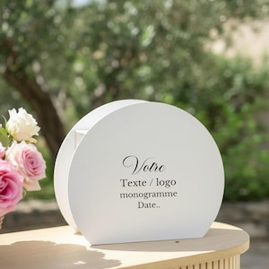 Può includere: Una scatola in legno semicircolare bianca con il testo stampato in nero Votre Texte / logo monogramme Date.. L'oggetto è posizionato accanto a un piccolo bouquet di rose rosa chiaro e bianche, con una finitura liscia e opaca.