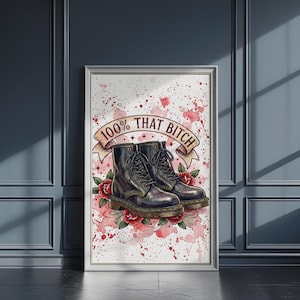 Könnte beinhalten: Gerahmter Kunstdruck mit einem Paar schwarzer Kampfstiefel mit Schnürsenkeln, umgeben von roten Rosen und einem Banner mit der Aufschrift "100% THAT BITCH" vor einem rosa-weißen Spritzerhintergrund.