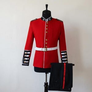 May include: A red military jacket with gold buttons, white trim, and a white belt. The jacket is paired with black trousers featuring a red stripe. The uniform is displayed on a mannequin against a plain background.
