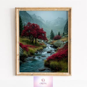 Puede incluir: Impresión artística enmarcada de un paisaje montañoso con un río. Un árbol rojo vibrante destaca sobre el fondo de las montañas y un río que fluye. La obra de arte está enmarcada en un marco de madera dorada.