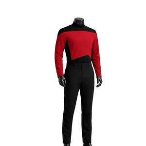 May include: A black and red uniform, comprising a long-sleeved top and trousers. The top features a black turtleneck and a red panel across the chest. The trousers are black and tailored. The outfit is displayed on a mannequin.