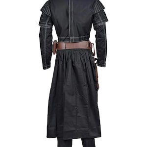 May include: A black long-sleeved jacket with white stitching details, paired with a matching black skirt and trousers. A brown leather belt with a holster and ammunition loops is worn around the waist, featuring a structured design and visible seams.