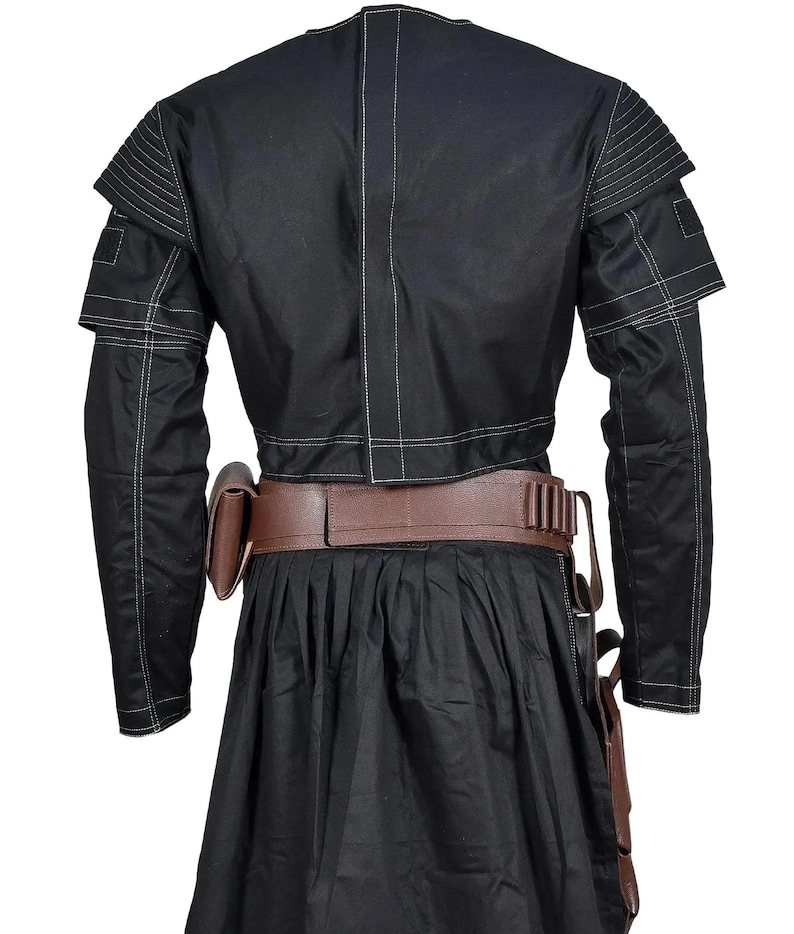May include: A black long-sleeved jacket with white topstitching, featuring ribbed shoulder panels and a central back seam. A brown leather utility belt with a side pouch and ammunition loops is worn over a black pleated skirt with a side holster.