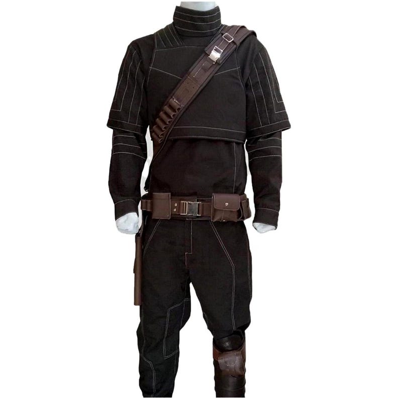 Op de afbeelding: Zwart kostuum met een hoge kraag, schouderriem en gereedschapsriem. De outfit heeft zichtbare stiksels en bevat een holster en kniebeschermer. Het kostuum wordt op een mannequin getoond.