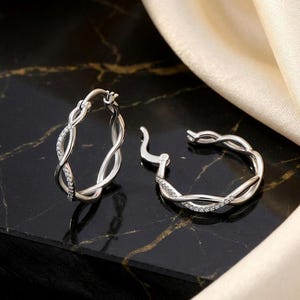 Pendientes de aro doble retorcidos de plata de ley 925 con circonitas cúbicas engastadas, estilo infinito.