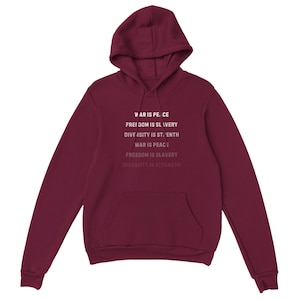 May include: A maroon hoodie with a front pocket and hood. The text "WAR IS PEACE, FREEDOM IS SLAVERY, DIVERSITY IS STRENGTH" is printed in white on the front. The hoodie is made of a soft material.