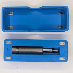 May include: A blue rectangular case with a matching lid, both containing embedded magnets. Inside the case is a silver metal cylindrical object. The case is open, revealing the contents.
