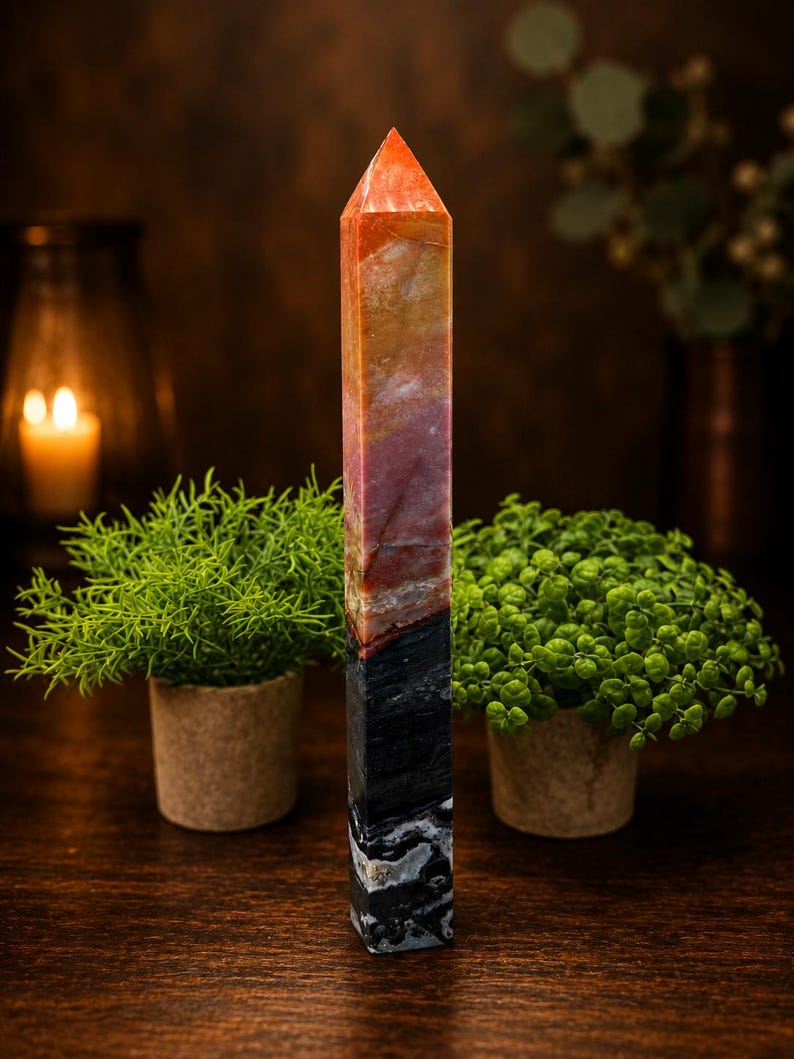 May include: A tall, multi-colored stone tower with a pointed, faceted top. The upper section features warm tones of orange, yellow, and pink, while the lower section transitions into a dark, solid black base with white, marbled, and textured patterns.