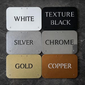 Pu&ograve; includere: Sei targhe metalliche rettangolari in bianco, nero, argento, cromo, oro e rame. Ogni targa ha un nome di colore diverso in rilievo in maiuscolo. Le targhe sono fissate con piccole viti.