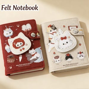 May include: Two felt notebooks. One is burgundy with cat and girl illustrations, the other is beige with cat illustrations. Both have a cat-shaped applique and a snap closure. The text "Felt Notebook" is at the top.