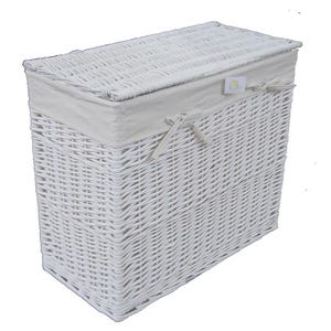 Puede incluir: Una cesta de mimbre blanca para la colada con forma rectangular y tapa con bisagras. La cesta tiene un forro de tela de color claro en el interior y un lazo decorativo en la parte delantera. El diseño tejido proporciona una apariencia texturizada.