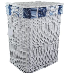 Puede incluir: Una cesta de lavandería de mimbre blanco con forma rectangular y tapa con bisagras. La tapa presenta un diseño de patchwork con tela estampada y floral azul y blanco. Una asa blanca y una etiqueta en blanco están adjuntas.
