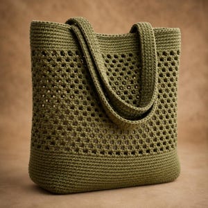May include: An olive green crochet tote bag featuring a solid base and a textured, open-work granny square pattern throughout the upper body. The bag includes two matching integrated handles and is constructed with a consistent yarn stitch.