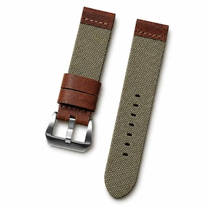 Può includere: Cinturino per orologio in due pezzi con materiale verde oliva simile alla tela e dettagli in pelle marrone. Il cinturino presenta una fibbia in acciaio inossidabile e passanti in pelle marrone. Il cinturino è progettato per un look classico e robusto.
