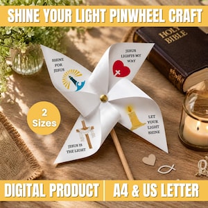 Może przedstawiać: Biały papierowy wiatraczek z czterema łopatkami ozdobionymi ilustracjami religijnymi i napisami takimi jak Shine for Jesus, Jesus Lights My Way, Jesus is the Light oraz Let Your Light Shine. Wiatraczek posiada drewniany patyczek i złoty pinezkowy środek.