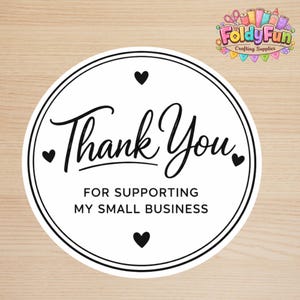 May include: A circular white sticker with a black double-line border featuring the text Thank You in a cursive script and FOR SUPPORTING MY SMALL BUSINESS in a sans-serif font, accented by four small black hearts positioned around the text.