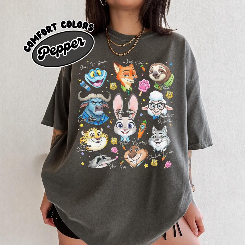 Dark gray Pepper Comfort Colors Zootopia shirt with a bold character ensemble print. The charcoal-toned fabric creates a striking contrast with the colorful artwork of Chief Bogo, Flash, and Officer Clawhauser. This vintage streetwear aesthetic is perfect for adults looking for a cool Disney graphic tee. The oversized fit and heavyweight cotton provide a premium feel and long-lasting durability. Great for casual everyday wear or as a unique souvenir for your next magical theme park vacation.