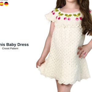 May include: A cream-colored crochet baby dress with a cherry design around the neckline. The dress has short sleeves and a flared skirt. The text "Hanis Baby Dress Crochet Pattern" is displayed on the left side.