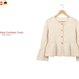 Puede incluir: Un cárdigan túnica de manga larga en color crema con cuello redondo, cuatro botones de color marrón claro y un dobladillo con volante. El texto Baris Baby Cardigan Tunic Knitt Pattern aparece a la izquierda de la prenda en una percha de madera.