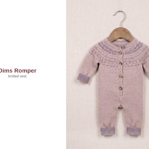Op de afbeelding: Een lichtpaarse gebreide babyromper met een knoopsluiting aan de voorkant en lange mouwen, hangend aan een houten hanger. De romper heeft een decoratief patroon rond de halslijn en manchetten. De tekst "Dims Romper knitted vest" staat links.