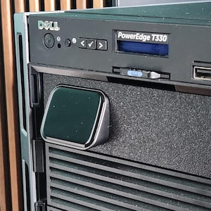 May include: A Dell PowerEdge T330 server, predominantly black and silver. The front panel displays the Dell logo, a screen, and USB ports. This server is designed for business applications and data storage.