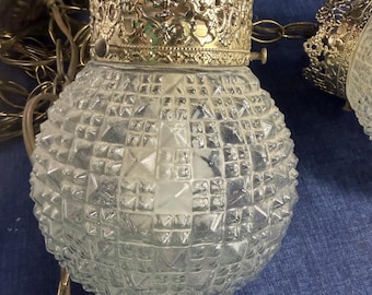 Vintage dubbele hanglampen met getextureerde glazen bollen en sierlijke metalen kapjes.