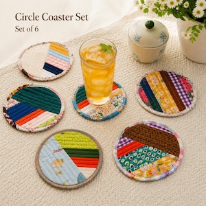 May include: A set of six colorful, quilted circle coasters. Each coaster features a unique patchwork design with various fabrics in shades of blue, green, red, yellow, and floral patterns. The text "Circle Coaster Set" and "Set of 6" is visible.