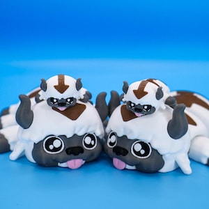 May include: A set of three ceramic mugs with a speckled, matte finish. The mugs are in shades of cream, light gray, and dark gray. Each mug has a simple, minimalist design, perfect for coffee or tea.