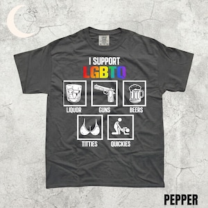 May include: Dark gray t-shirt with the text "I SUPPORT LGBTQ" in rainbow colors. Below the text are six white outlined images with the words "LIQUOR", "GUNS", "BEERS", "TITTIES", and "QUICKIES". The word "PEPPER" is at the bottom.