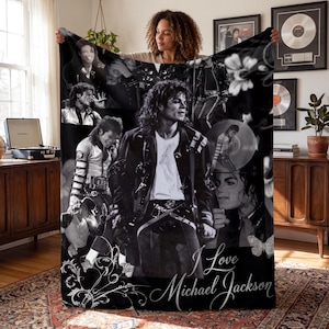 May include: A black and white fleece blanket featuring a collage of Michael Jackson photographs, including performance shots and portraits, with decorative floral accents and the script text "I Love Michael Jackson" printed at the bottom.
