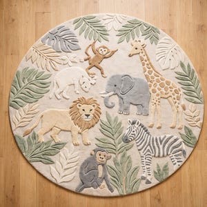May include: A circular rug with a jungle animal design. The rug features a lion, elephant, giraffe, zebra, monkey, and rhino, surrounded by green and beige leaves. The rug is made of a soft material.