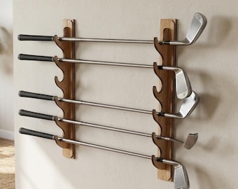 May include: A wooden golf club rack mounted on a beige wall, holding several golf clubs. The rack is made of dark wood with a natural finish, and the clubs are arranged horizontally. The golf clubs have black grips and silver shafts.