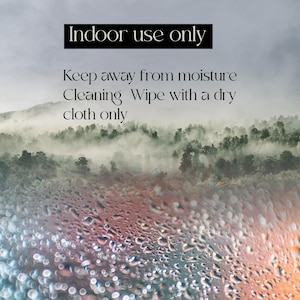 May include: Image with text: "Indoor use only. Keep away from moisture. Cleaning: Wipe with a dry cloth only." The background shows a misty forest with water droplets on the foreground.