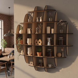 May include: A unique, round wooden wall shelf with multiple compartments. The shelves are filled with decorative items like small plants, candles, vases, and figurines. The shelf is mounted on a neutral-colored wall, creating a modern display.