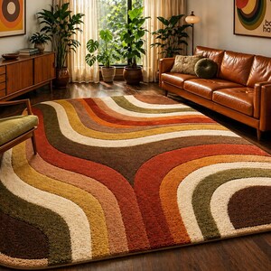 Può includere: Un tappeto in stile retrò con un motivo ondulato a forma di arcobaleno nei toni del marrone, arancione, giallo, verde e crema. Il tappeto è posizionato su un pavimento in legno scuro, che completa i toni caldi dell'arredamento della stanza. Il design del tappeto aggiunge un tocco vintage e vibrante.