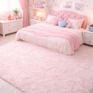 May include: A light pink bedroom with a large, fluffy rug. The bed has a pink tufted headboard and is covered with white bedding and a pink blanket. Pink curtains frame a window, and white furniture is placed around the room.