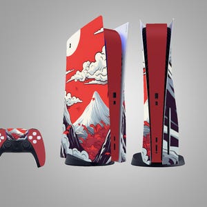 May include: A red and black game console and controller set. The console features a mountain and cloud design on the side panels. The controller is red and black with white buttons.