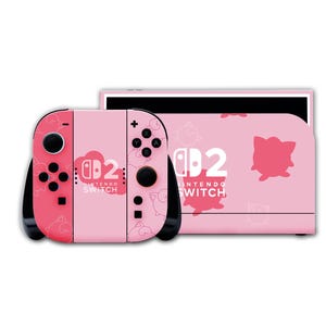 May include: A pink Nintendo Switch console and controllers. The controllers are two-toned pink with black buttons and the text "Nintendo Switch". The console is also pink with a matching design.